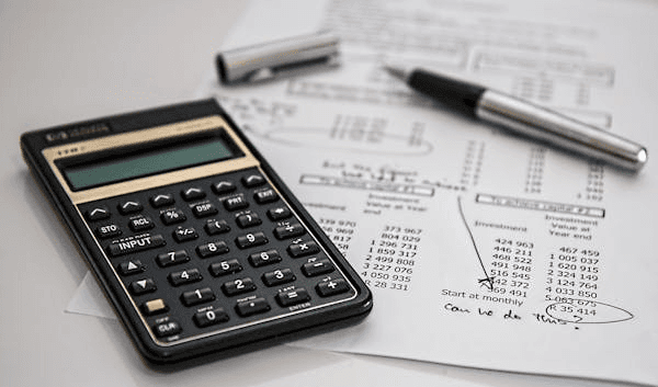 Calculator and financial documents on a desk, symbolizing the expertise of CPAs in managing finances for medical clinics in the USA.