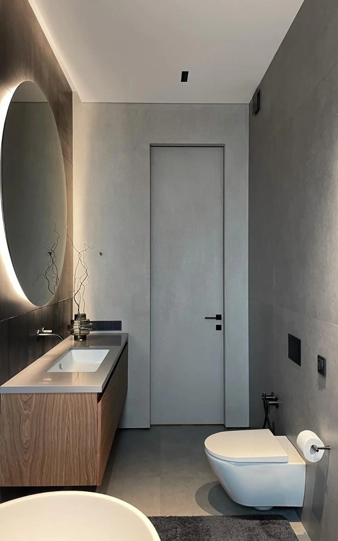 Salle de bains — WC suspendu et évacuation dissimulée.