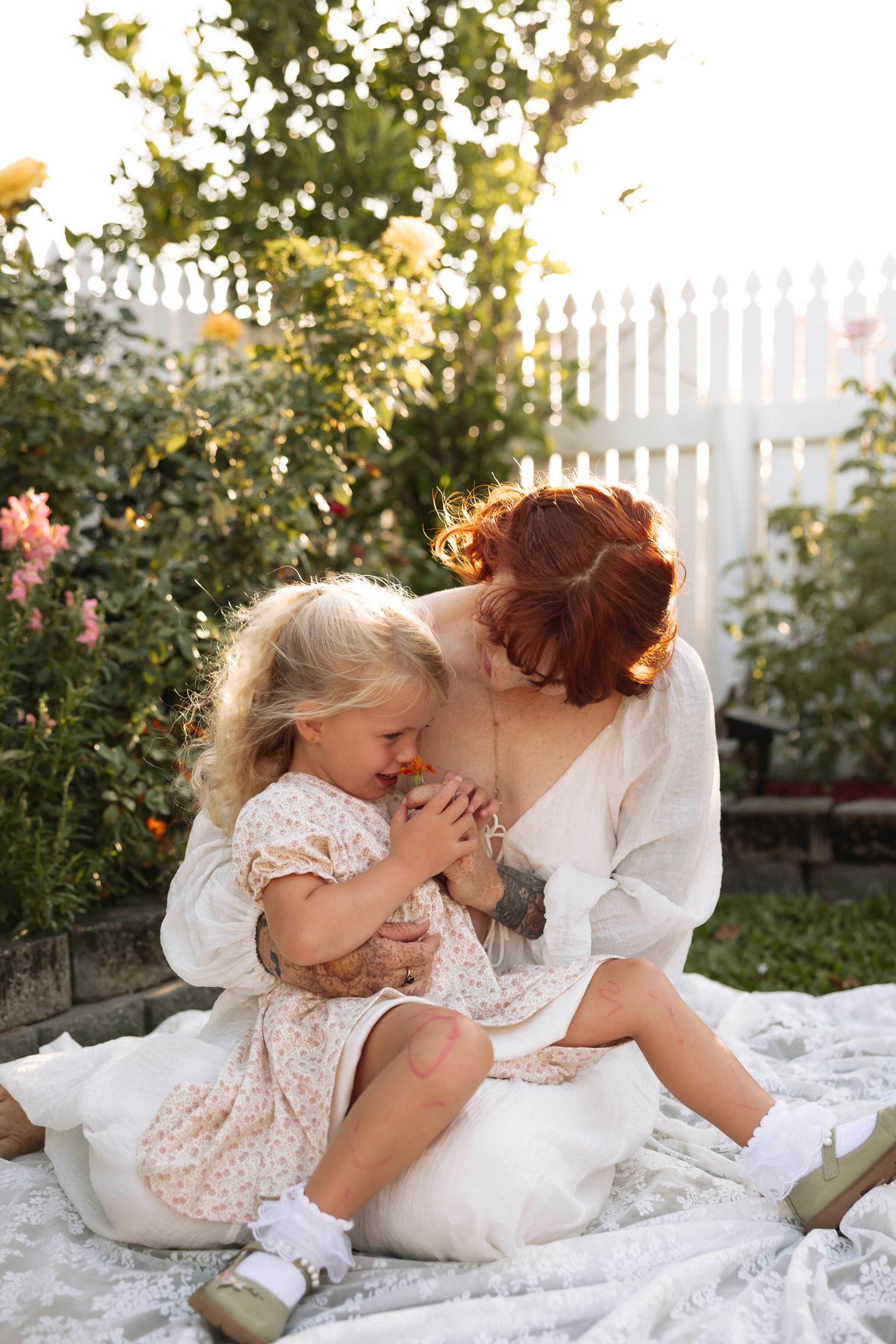 Mother cuddling daughter during outdoor family photo session in Mackay