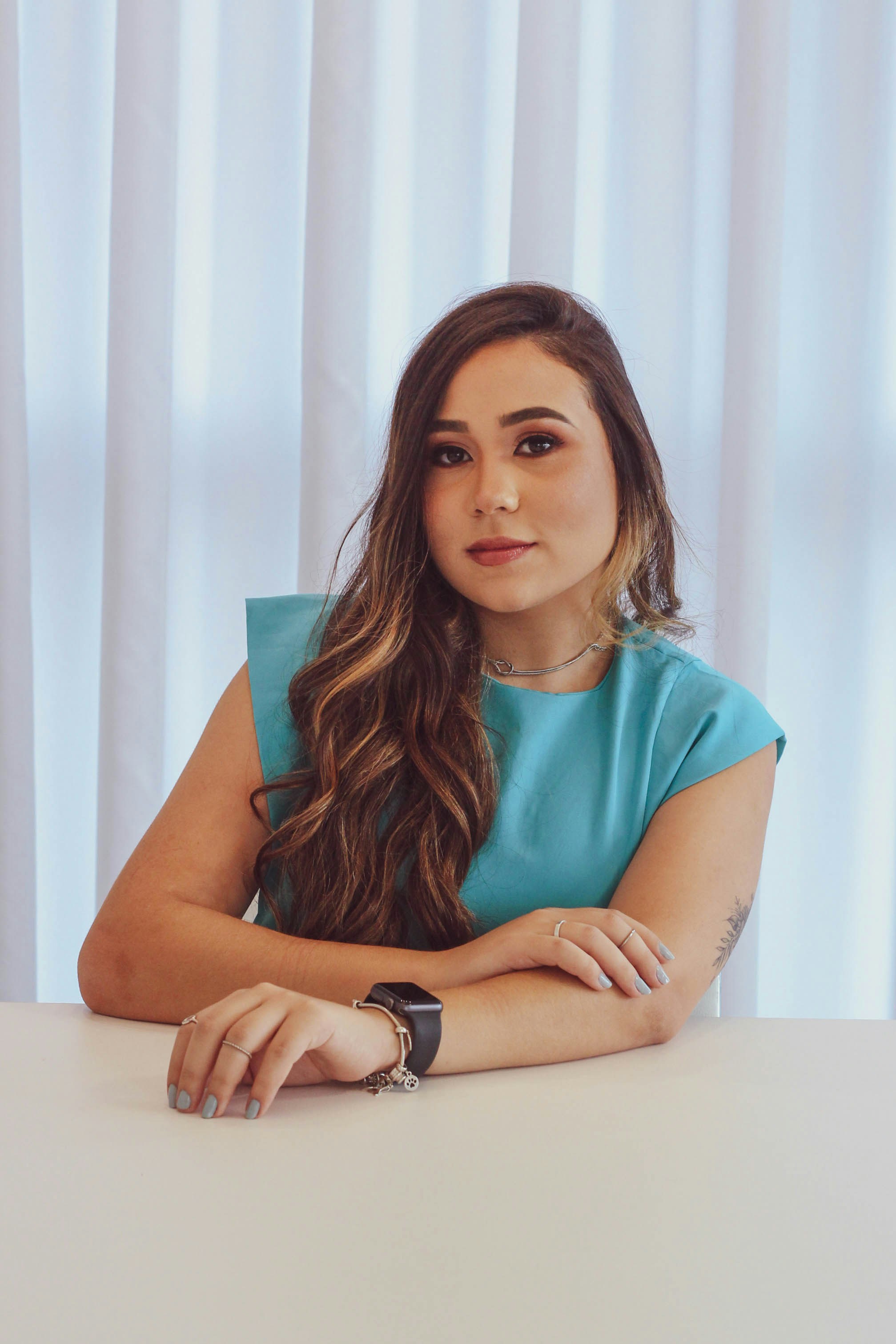 a woman sitting at a table with her arms crossed