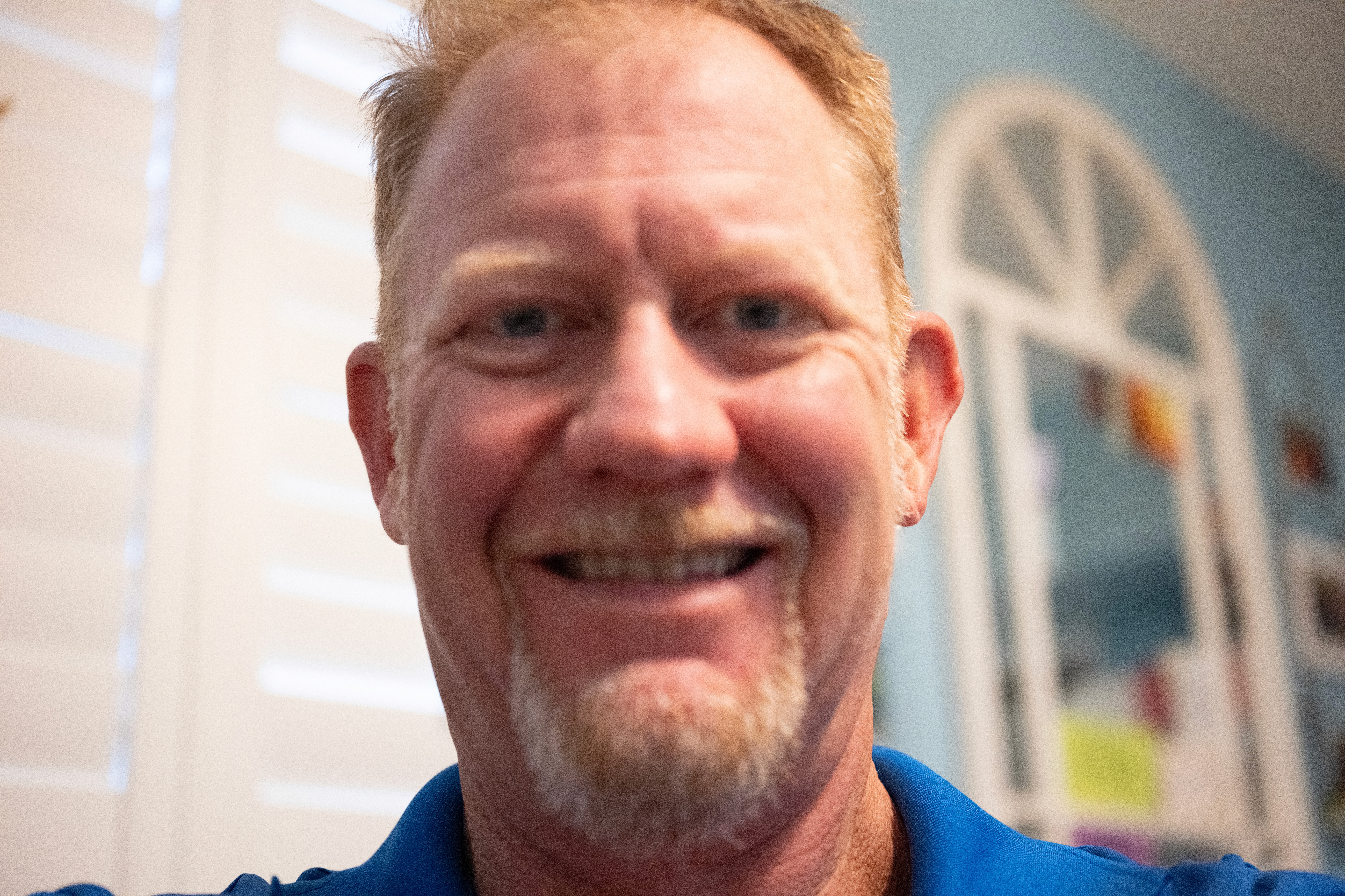 Profile portrait of a man in a white shirt against a light background