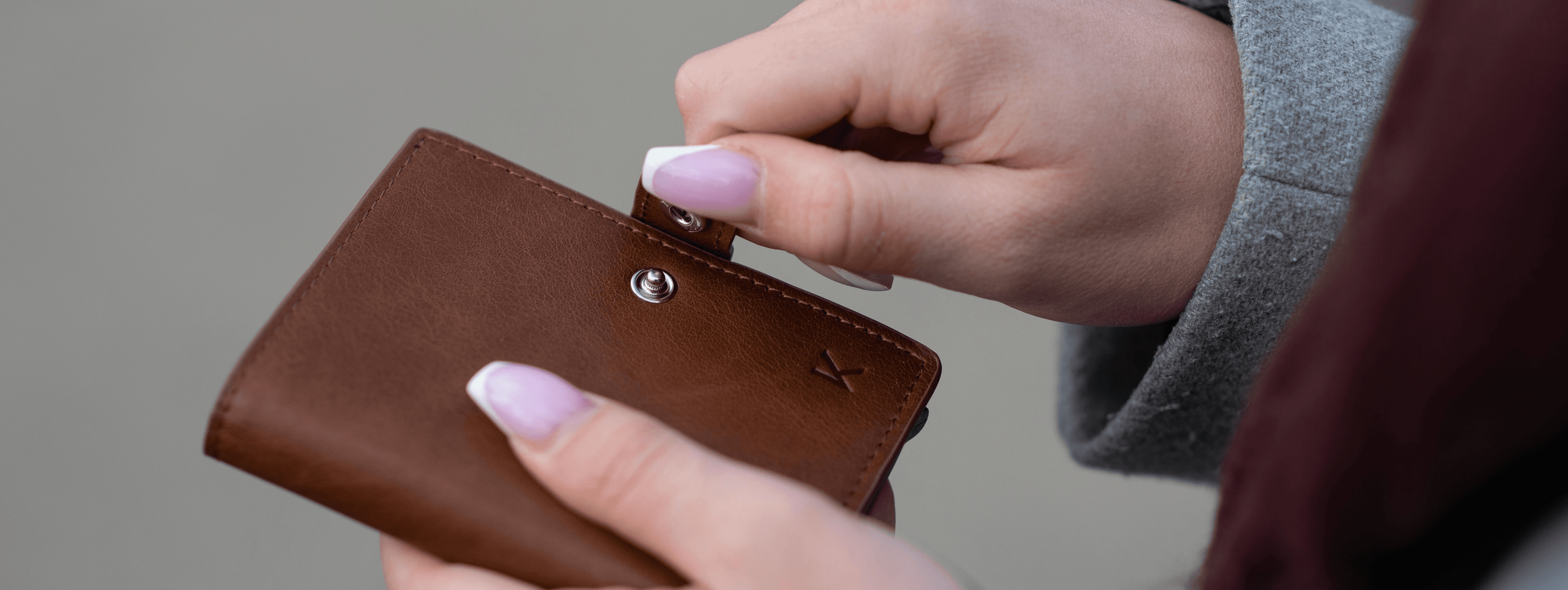person holding brown leather wallet