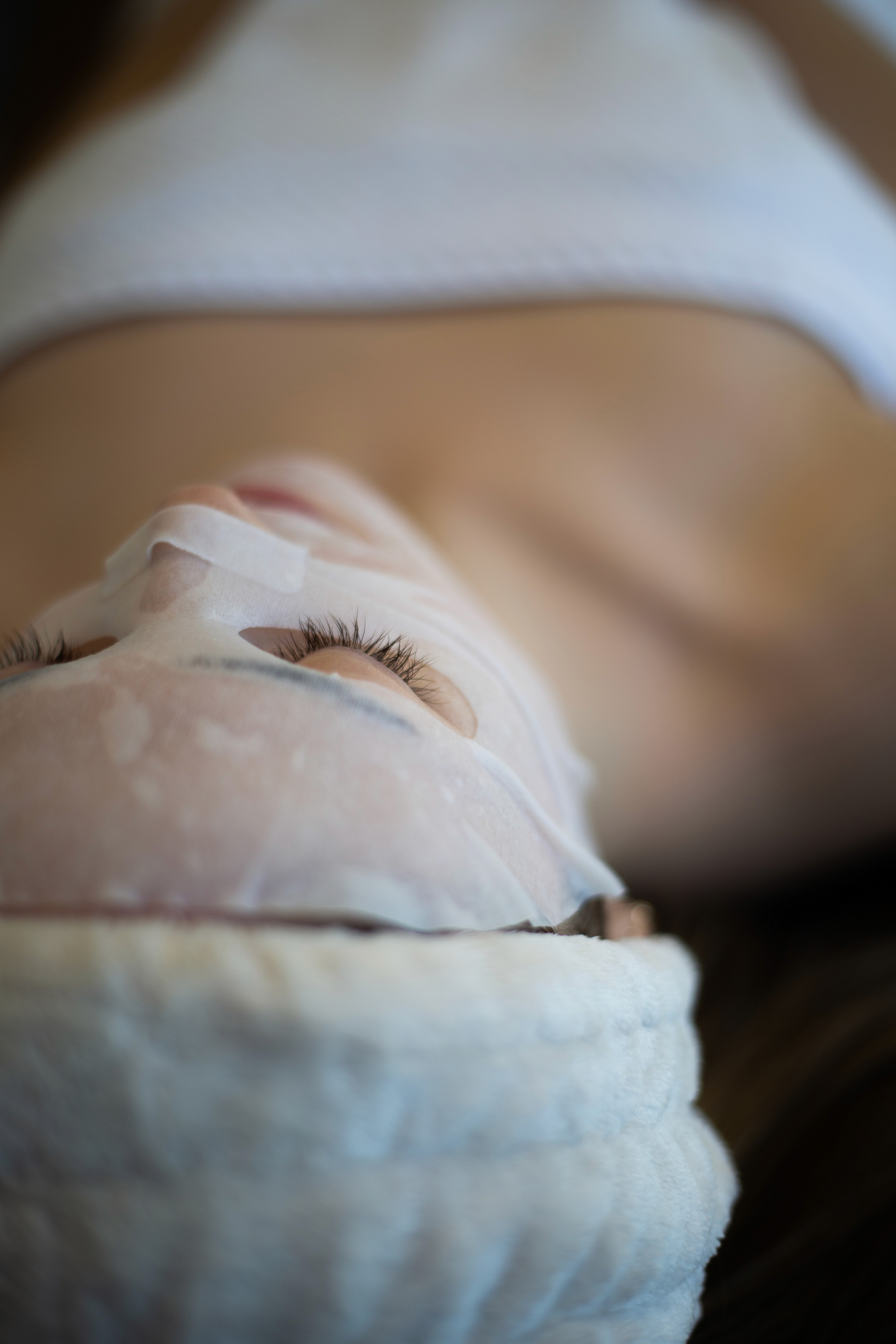 Person lying down with a facial mask applied during a spa treatment.