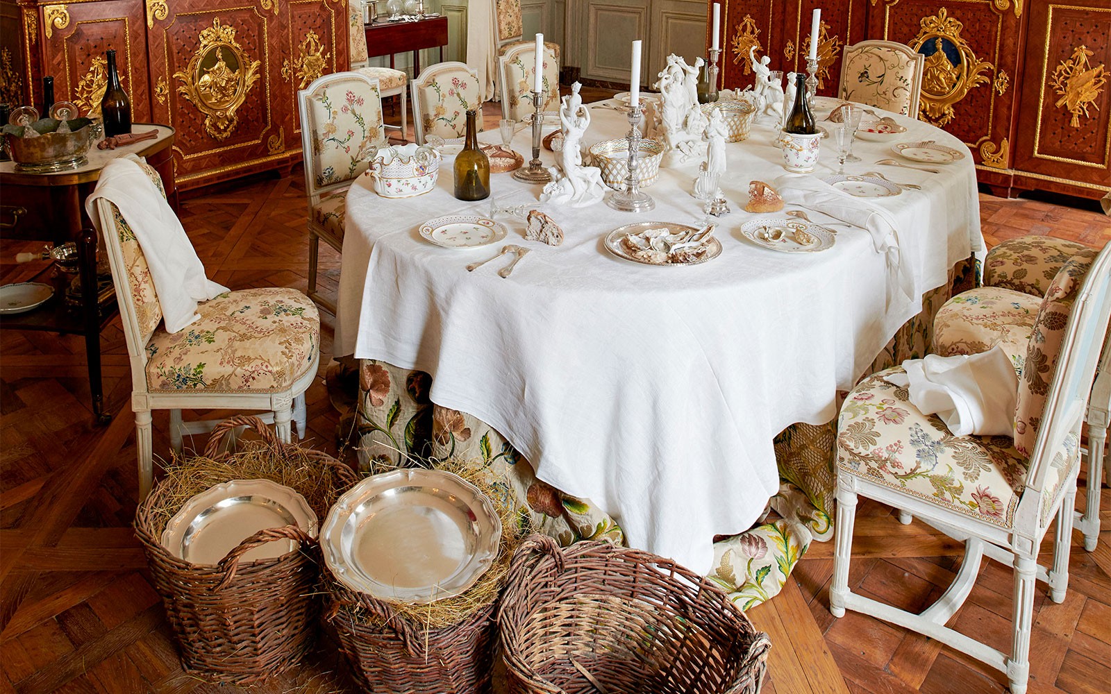 Configuração elegante da sala de jantar no Hôtel de la Marine, com talheres e cadeiras ornamentadas.