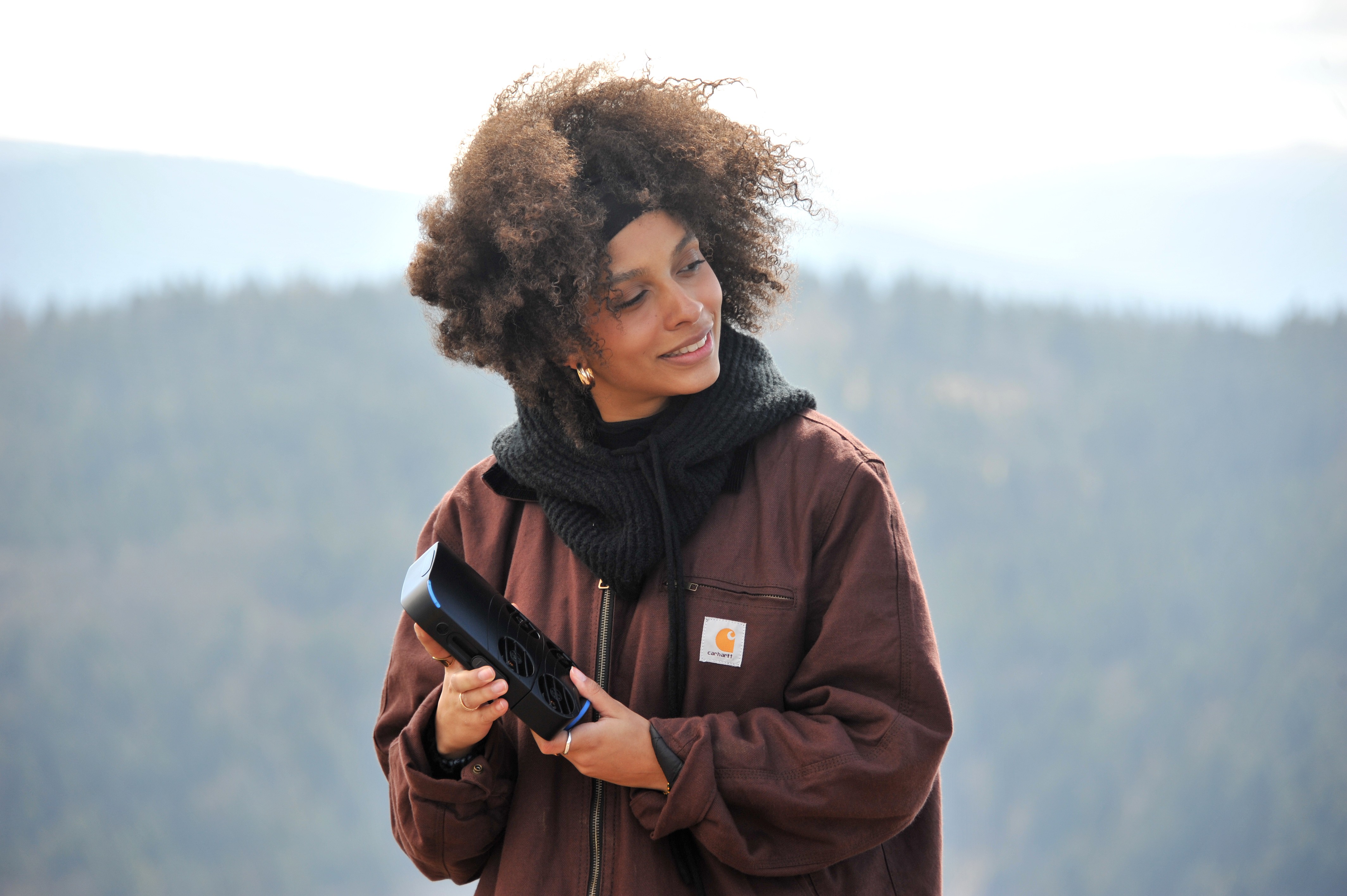 Film clapperboard in focus with glowing orange background, misty street, and silhouettes of people and lights; conveys mystery and anticipation.
