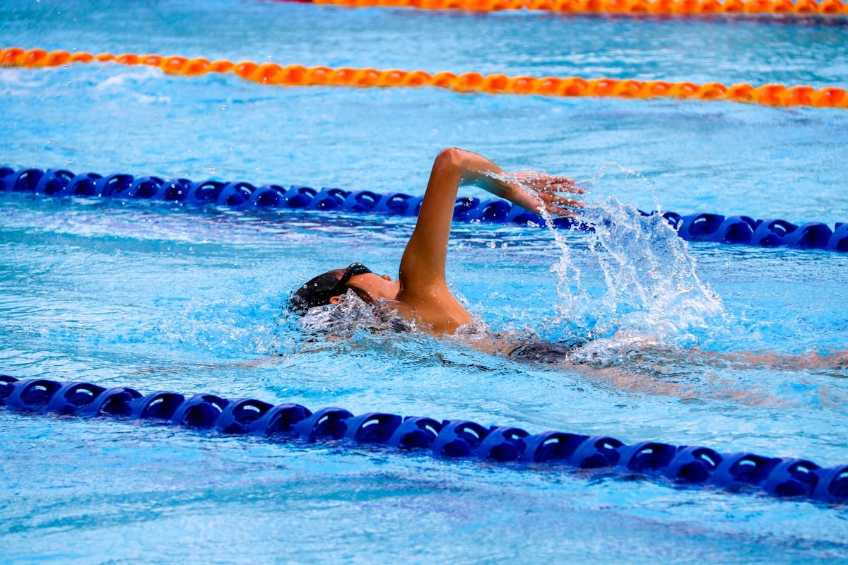 A young swimmer doing freestyle laps during a demanding training session.