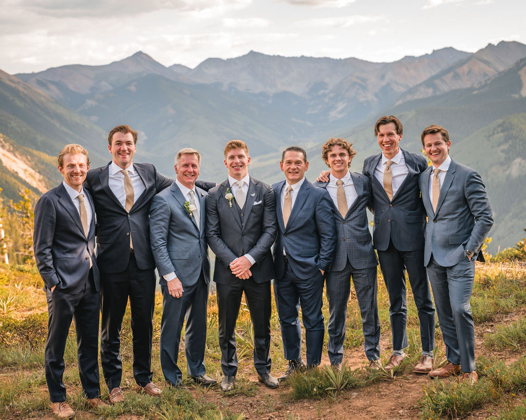Groom posing with groomsmen in front of mountain views