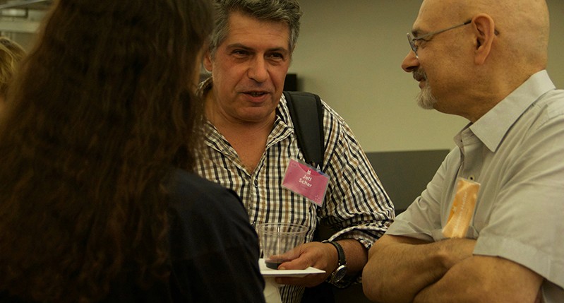 A photo of a group of people sitting in an office room and talking.