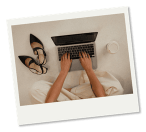 Polaroid of person sitting criss cross on floor typing on laptop