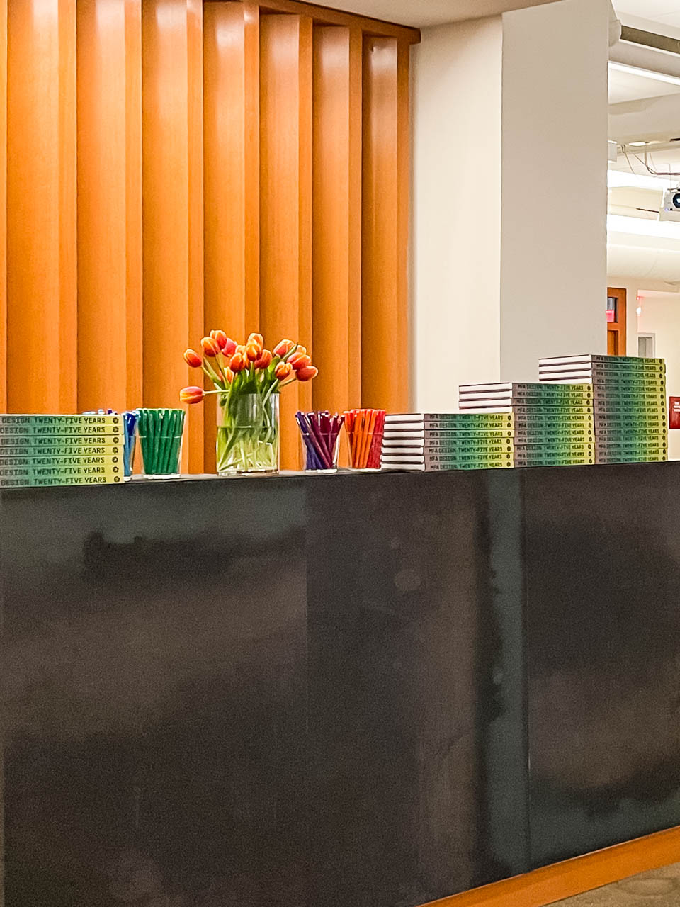 table with many multicolored books stacked up