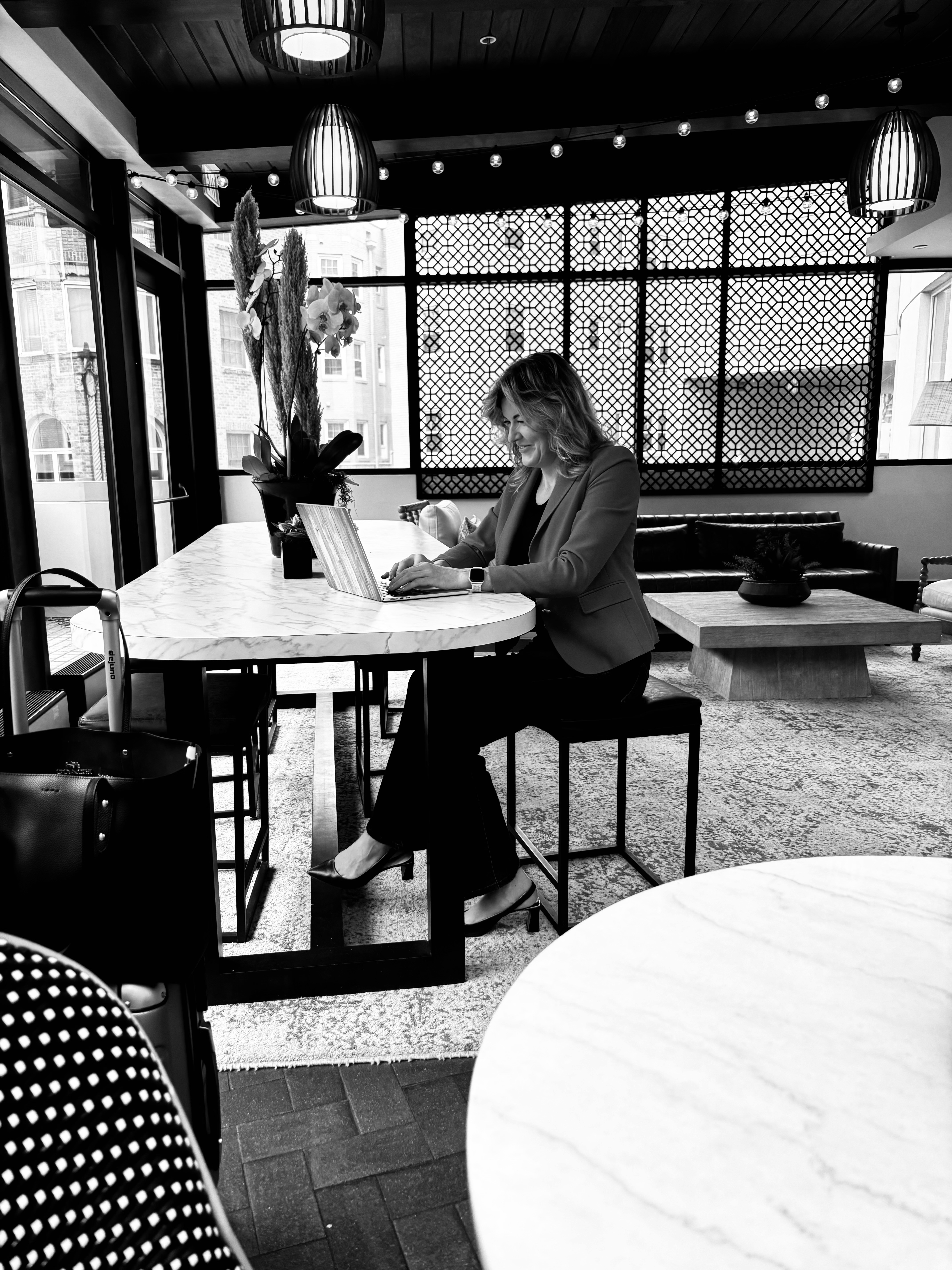 Jennifer Lea seated and working on a laptop