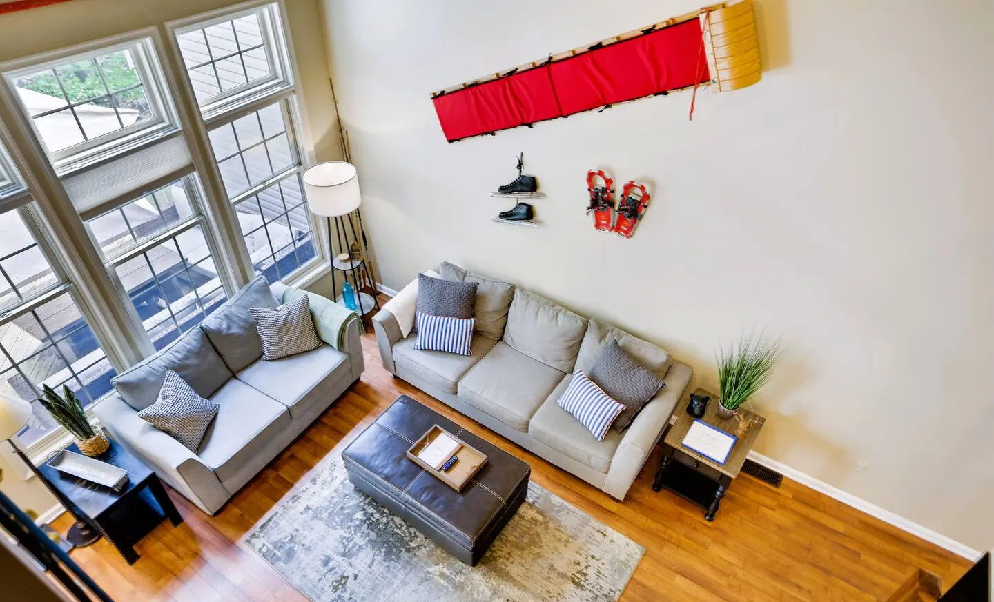 Vaulted living room with tall windows, gray sofas and ski decor at Pop's Place