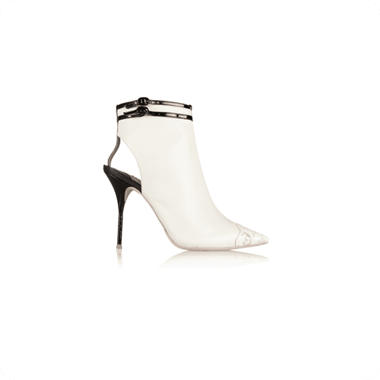 Woman wearing sleeveless black midi dress with white floral print, styled with black oxford shoes against tropical leaves