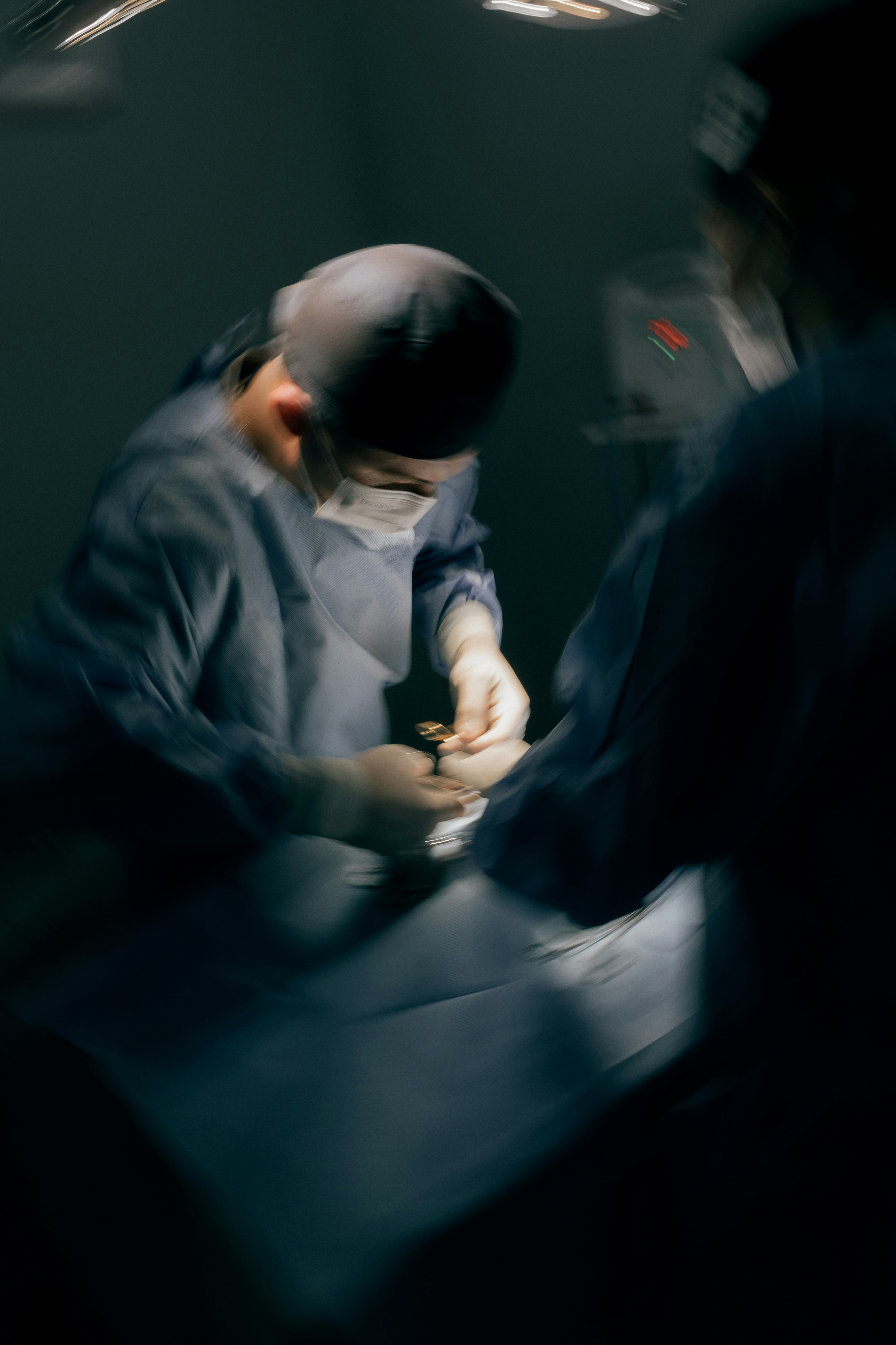 Surgeons performing a medical procedure in an operating room.
