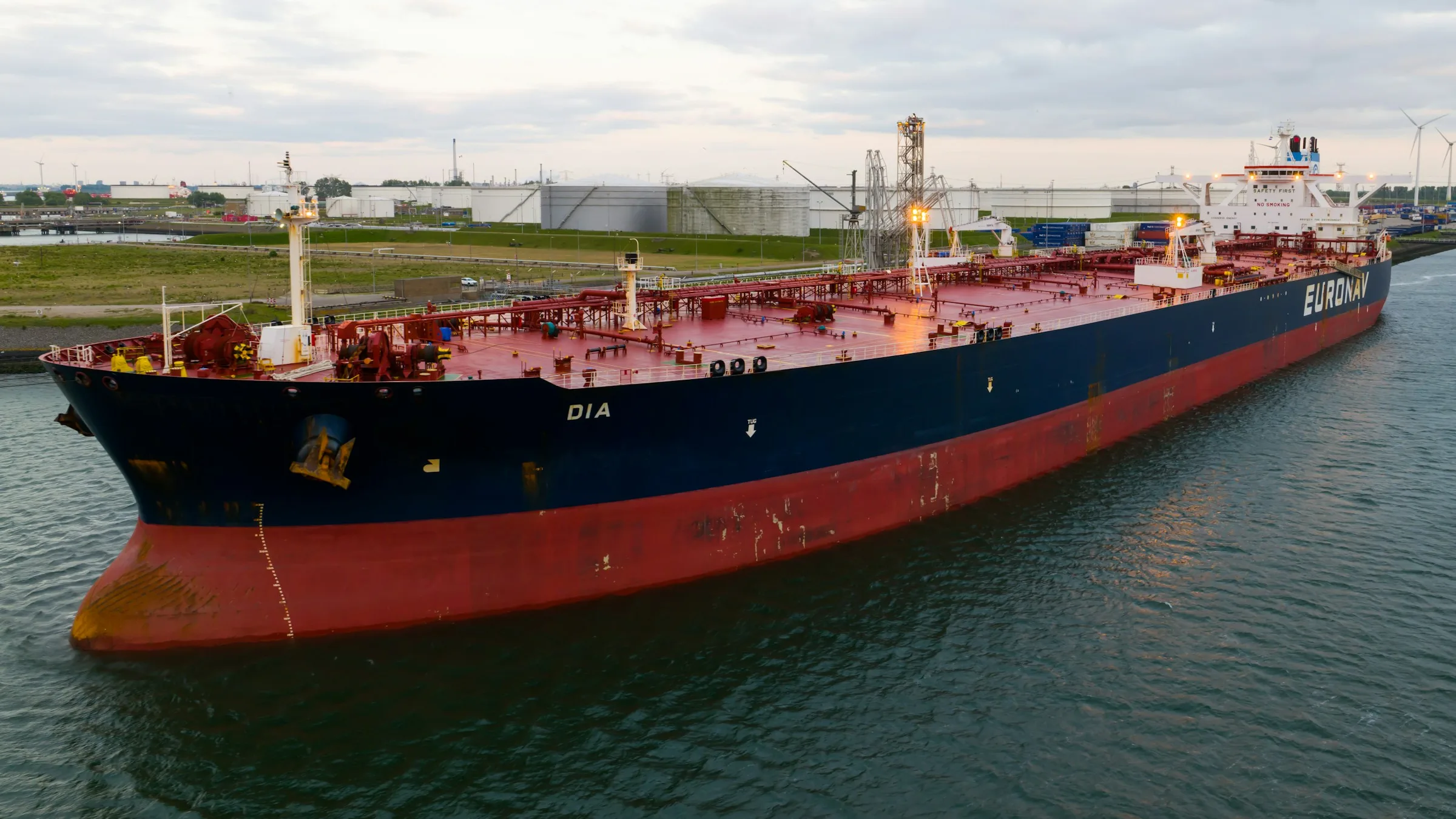 Large tanker ship moving through a harbor channel, the kind of vessel used to export ammonia