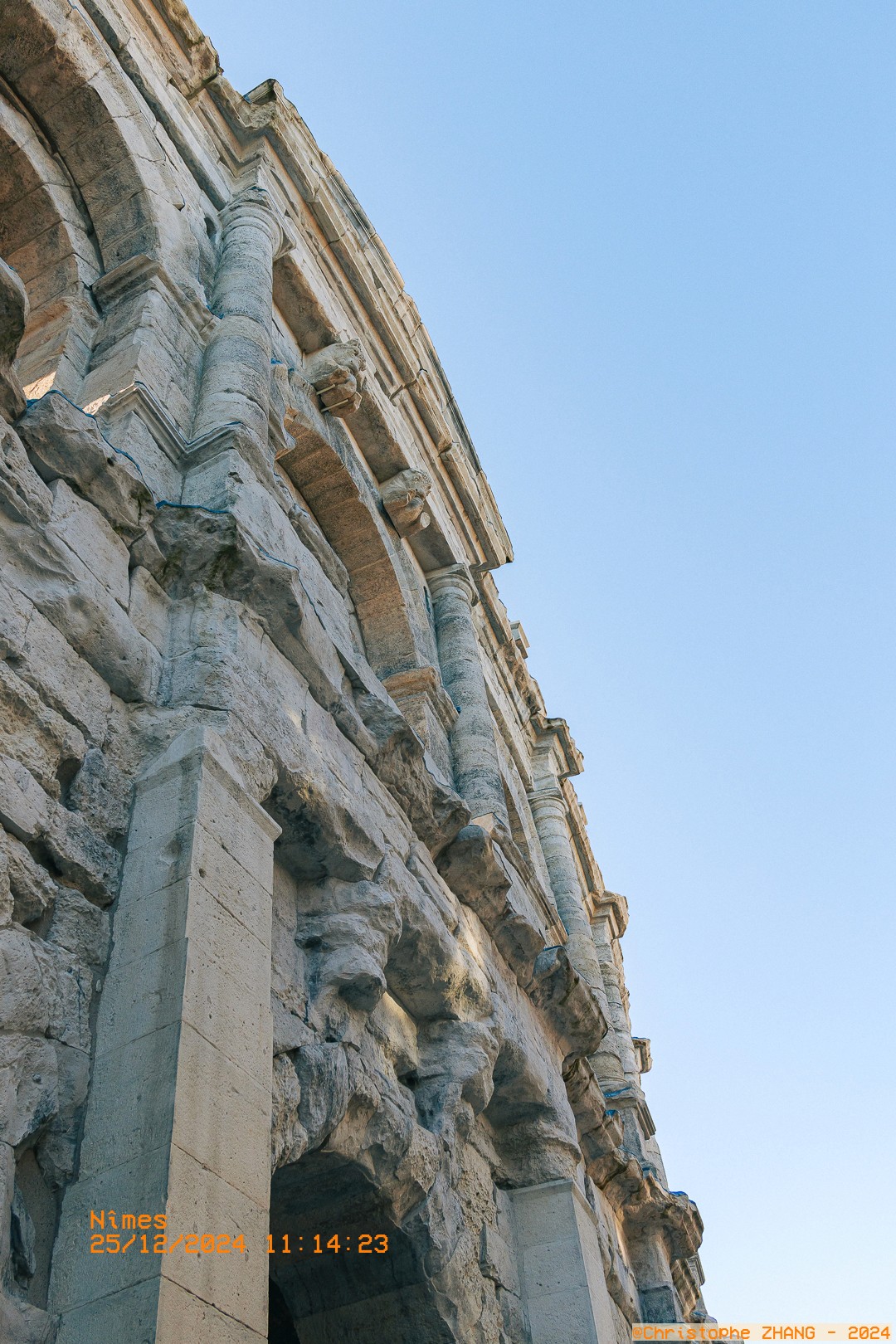 Détail architectural des arènes de Nîmes vu en contre-plongée.