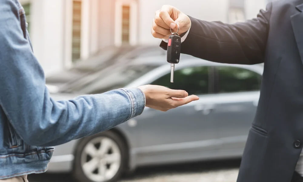 Un vendeur donne des clès a son nouveau propriétaire 