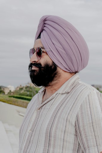 Man wearing a turban and sunglasses outdoors.