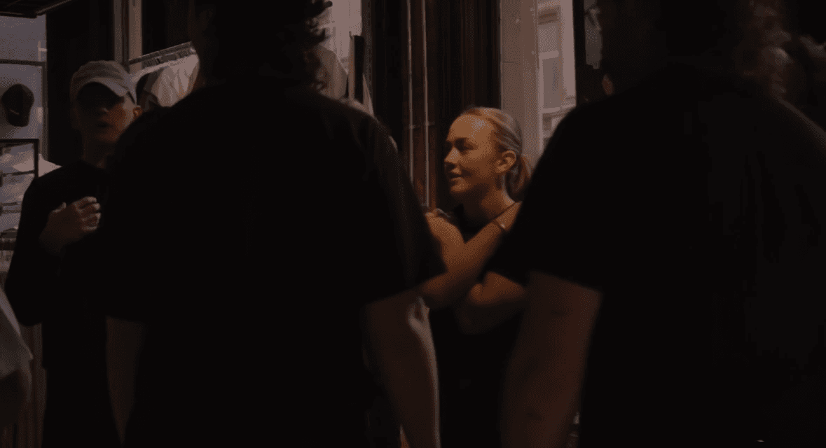 Group of young people talking outside a retail store during a street-style campaign shoot.