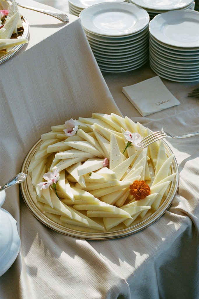 Wedding reception antipasti platter with sliced cheese arranged on a linen table