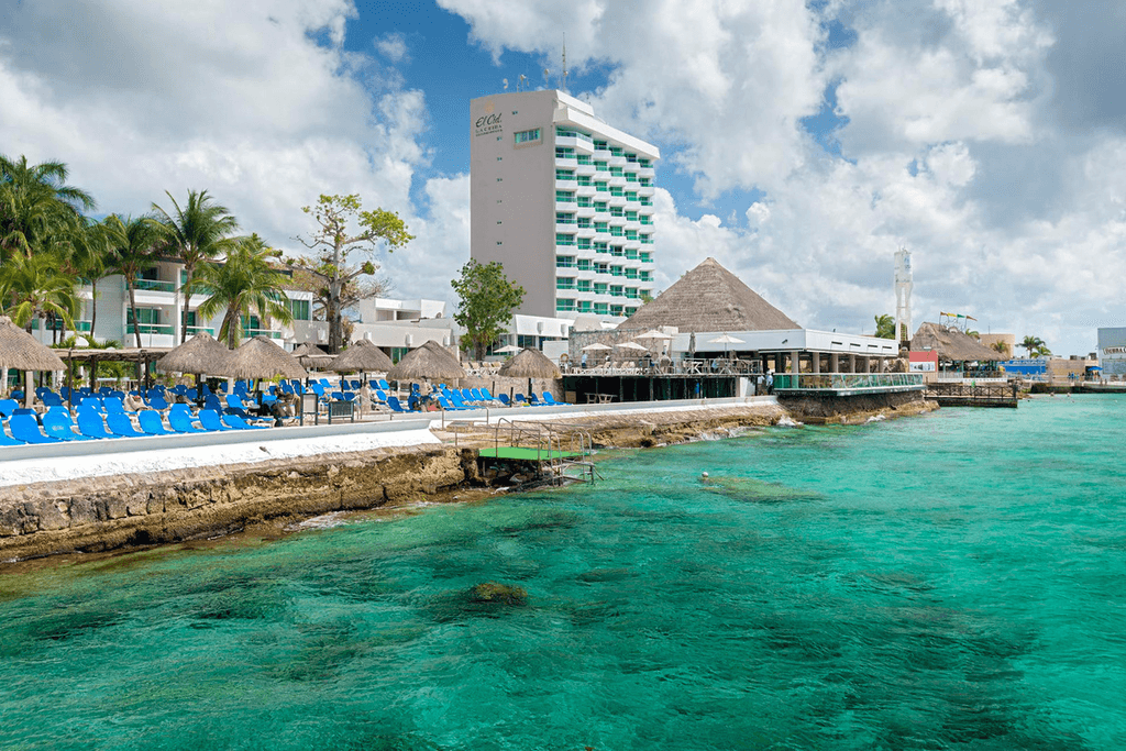 Couple standing on a balcony with binoculars in hand looking out over the ocean