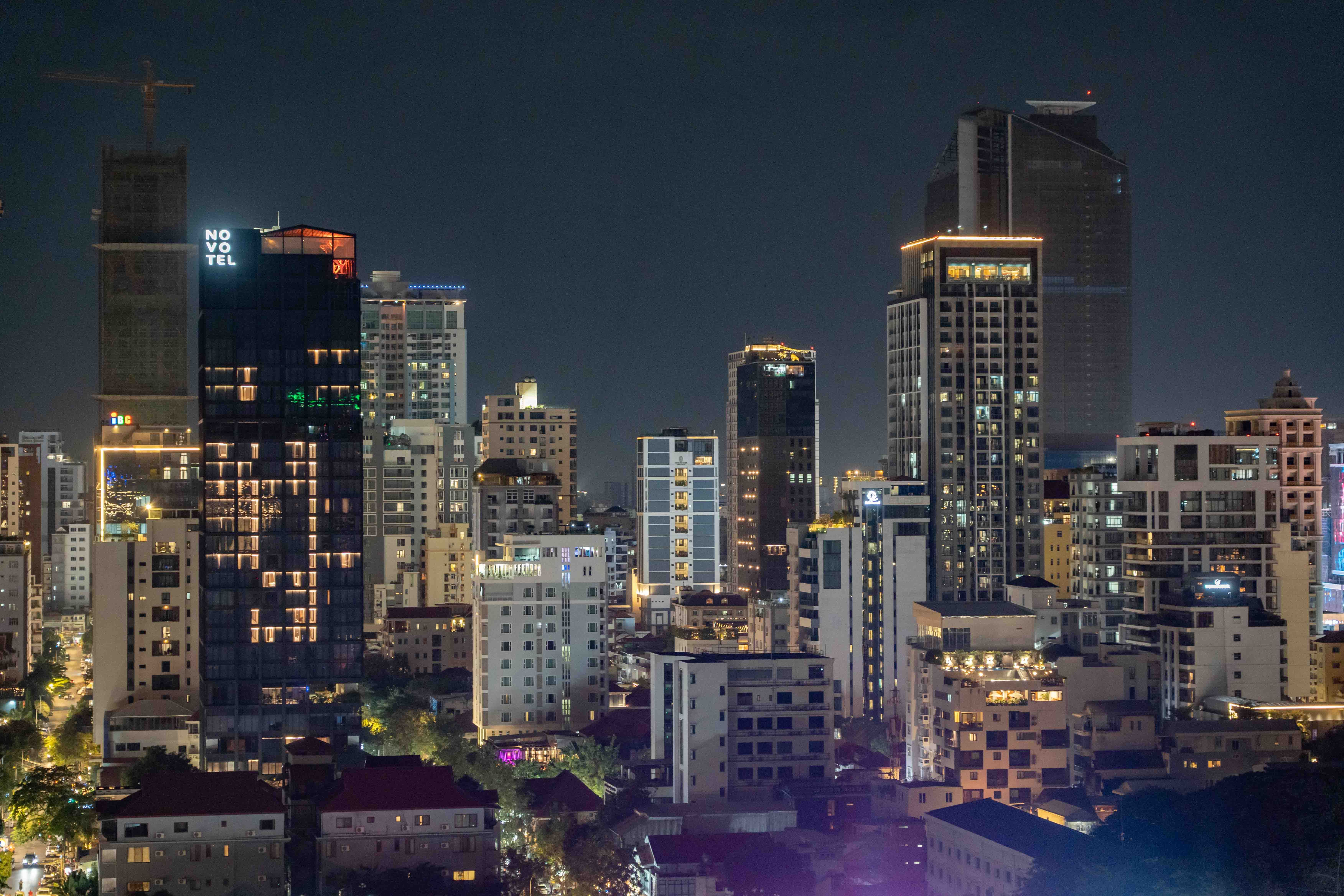 Phnom Penh commercial district at night showing buildings of varying scale, age and quality within the same urban area, illustrating how asset performance shapes long-term value beyond location alone