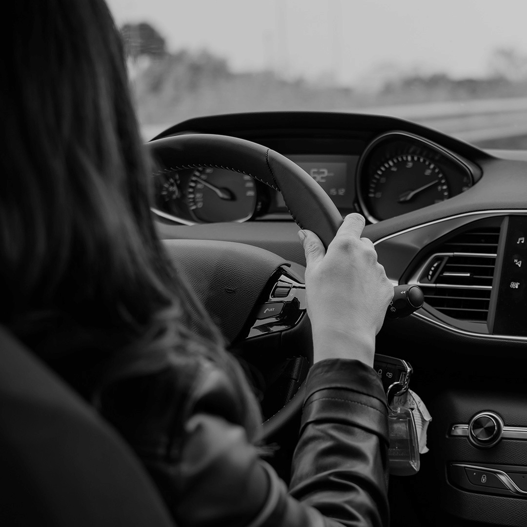 Black and white image of a security driver / chauffeur with hands on the steering wheel