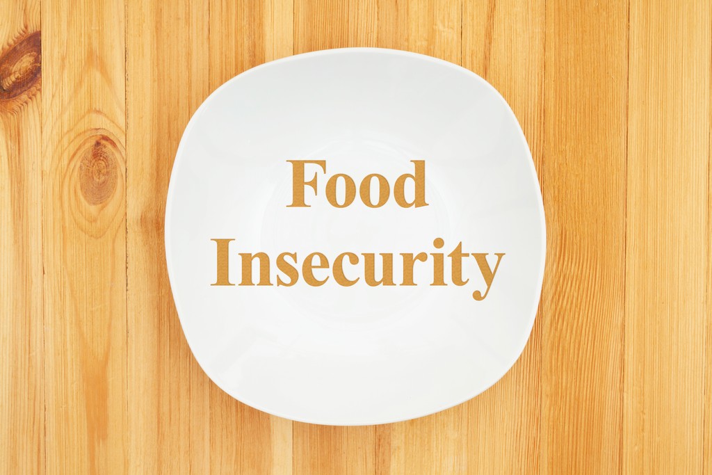 Food insecurity on plate with wood background