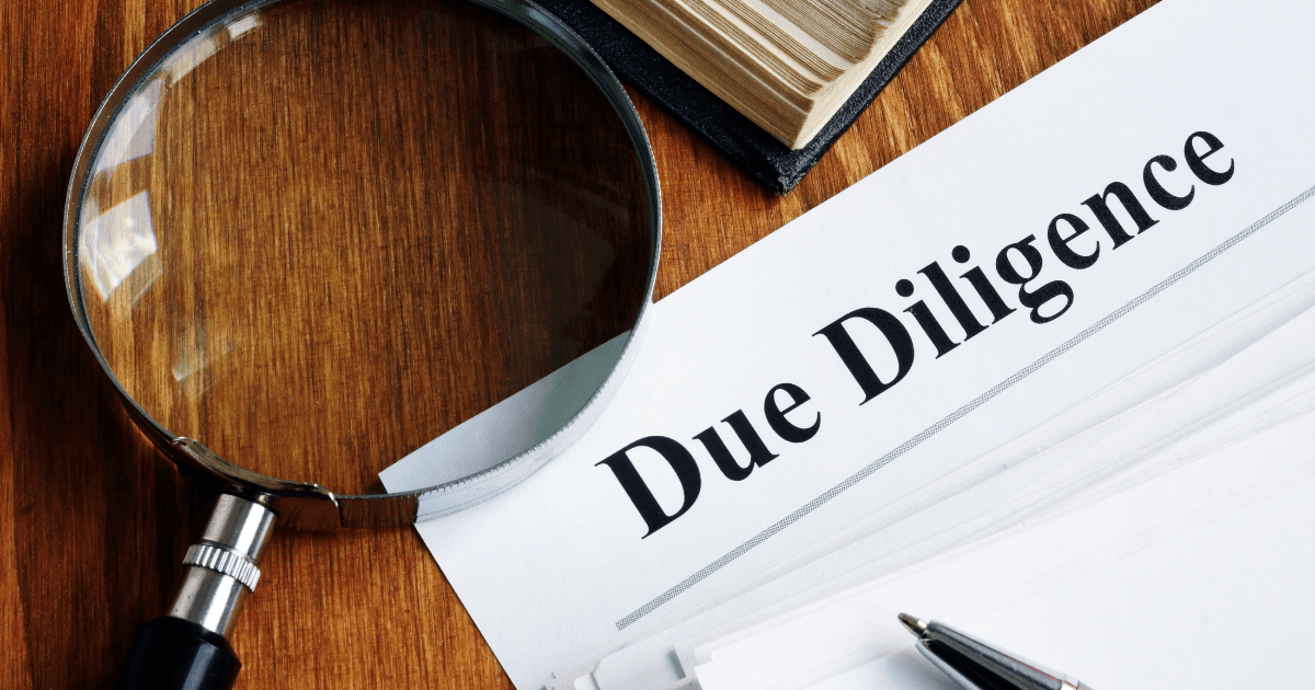 Focused man wearing a cap working on a laptop at a modern desk in a minimal office setting.