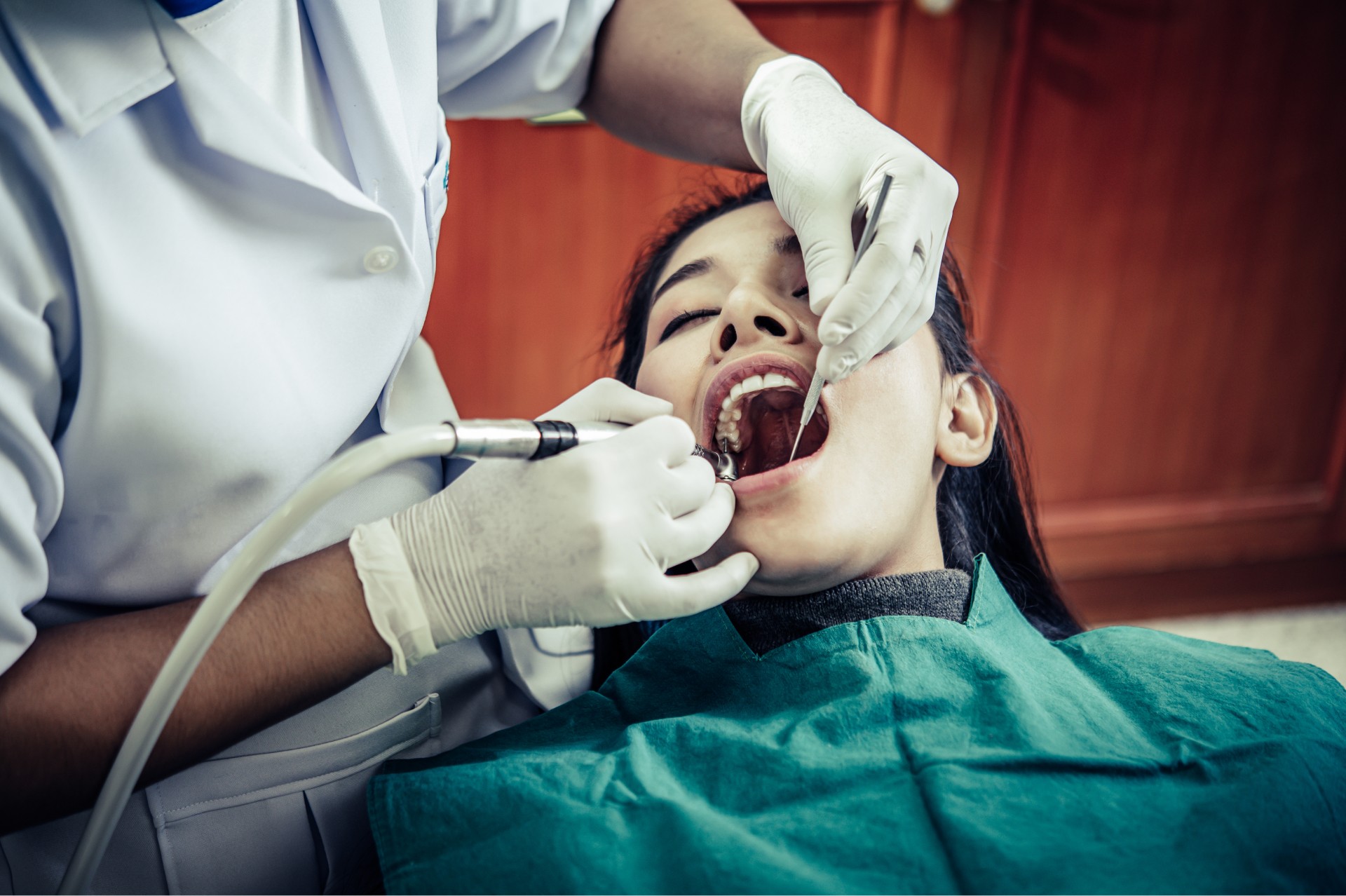 Dentist performing a dental procedure on a patient in an emergency appointment.