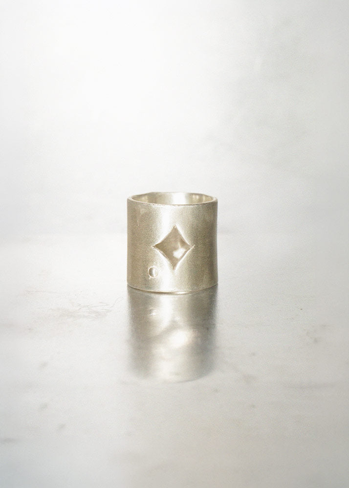Silver ring with a diamond-shaped design on a white background