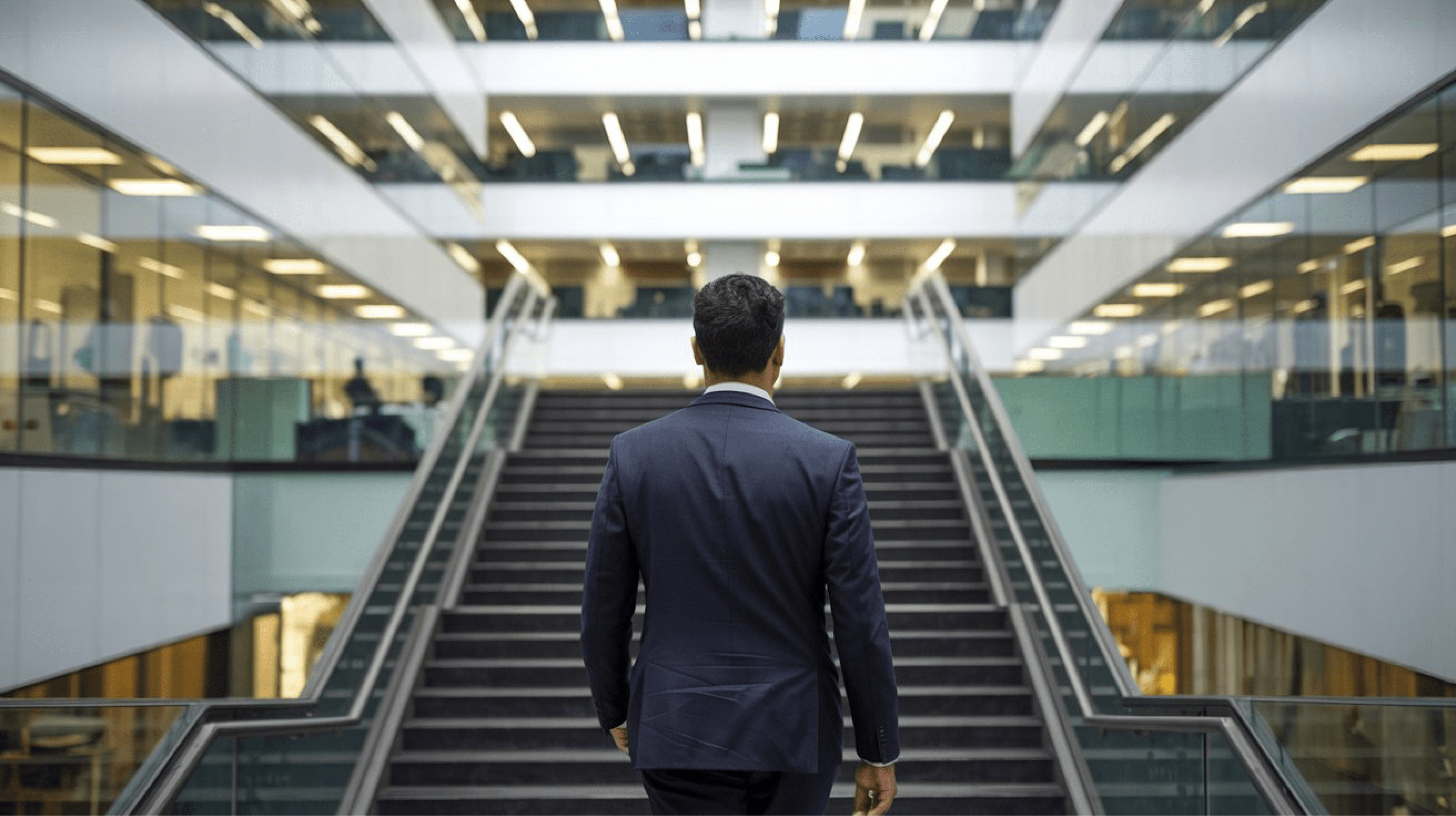 Professional man in a formal suit climbing stairs inside a modern glass building, symbolizing the health benefits of integrating walking into daily office routines.- Benefits of walking for heart health - Walking for cardiovascular health - Heart health exercises - Walking to lower blood pressure - Simple exercises for heart health - How walking improves heart health - Walking benefits for heart patients - Daily walking for healthy heart - Steps to improve heart health - Walking as exercise for heart care - Walking and heart disease prevention - Best exercise for heart health - Walking routine for cardiovascular health - Improve heart health with walking - Walking to reduce heart attack risk 