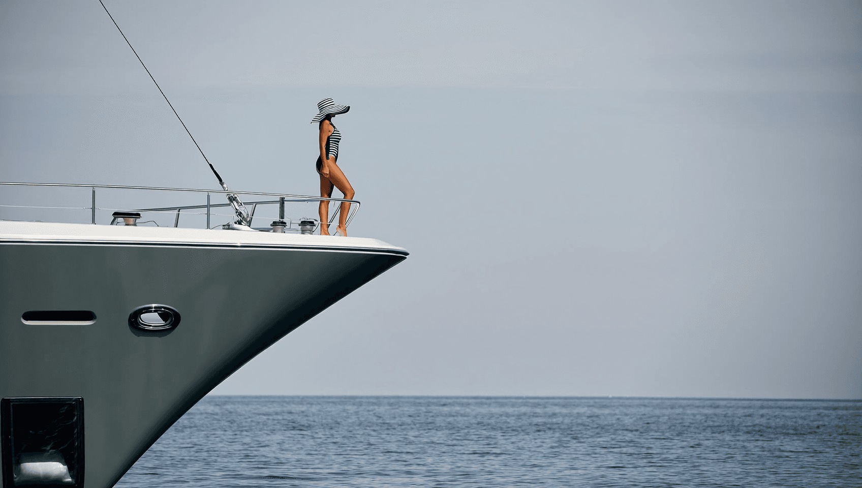 Lady on the beam of a yacht