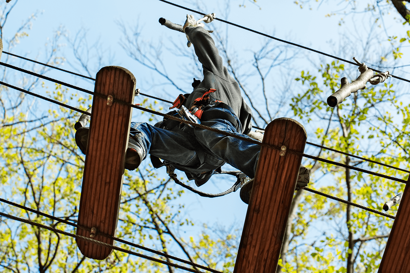 Upside-down view of person on adventure park obstacle course.