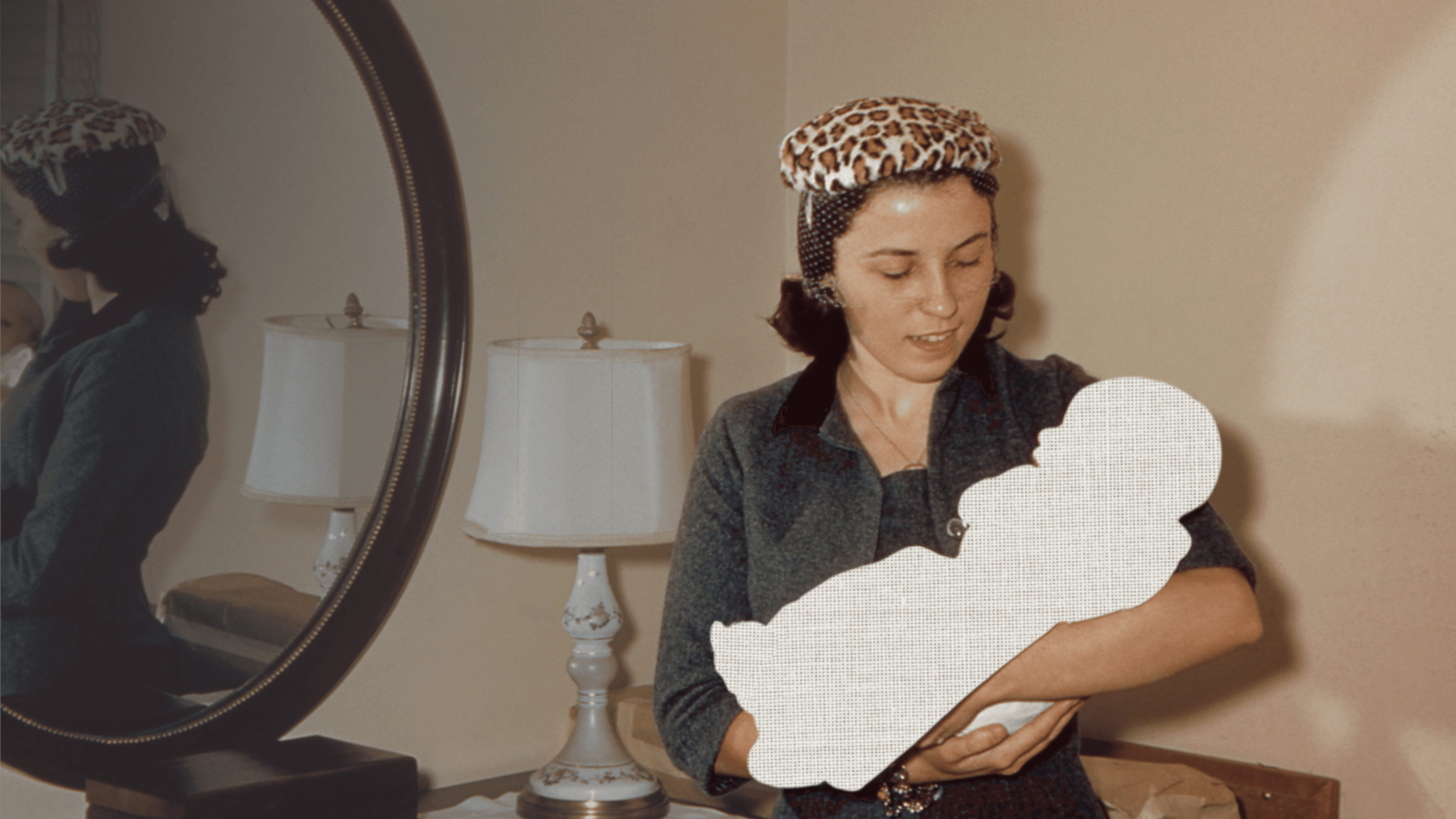 Woman holding a child-shaped paper cutout in a warmly lit home.