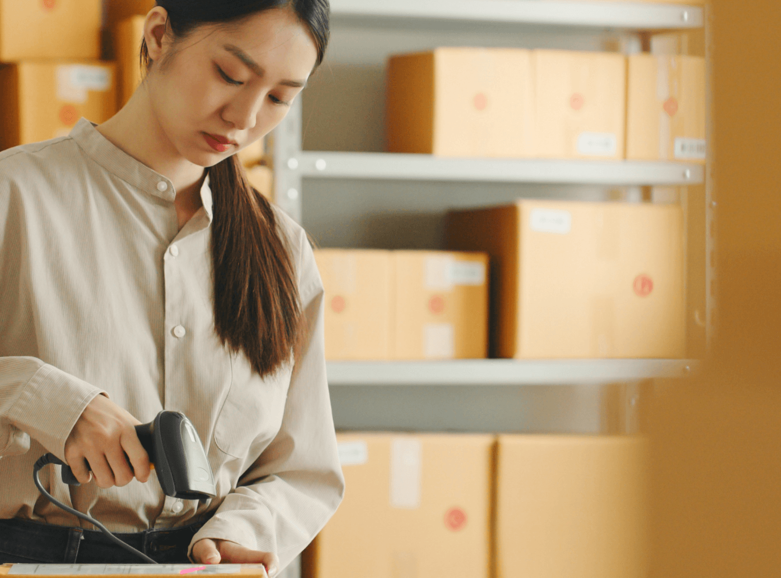 E-commerce worker scanning box in warehouse.