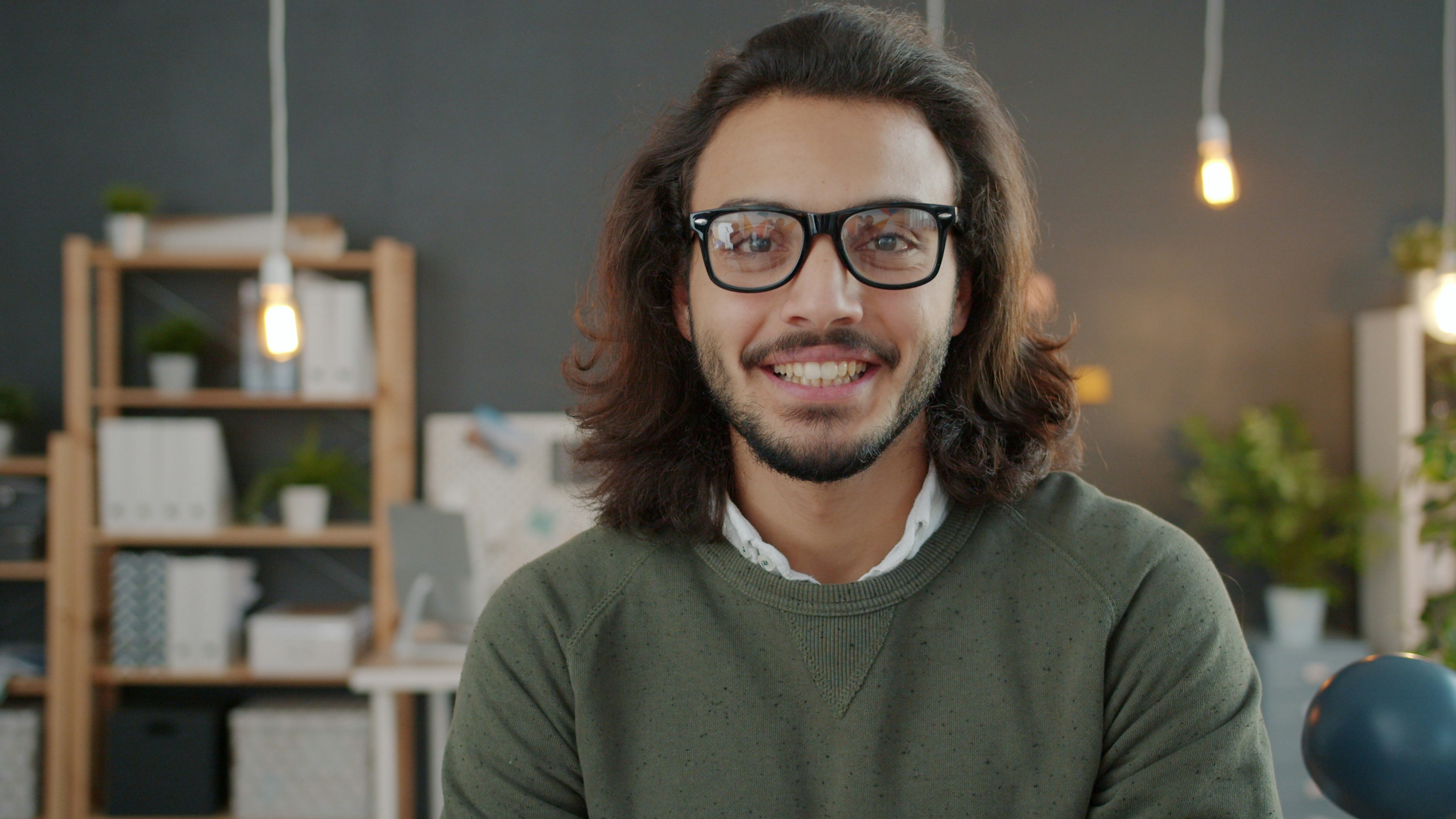 Man with glasses and long hair smiling