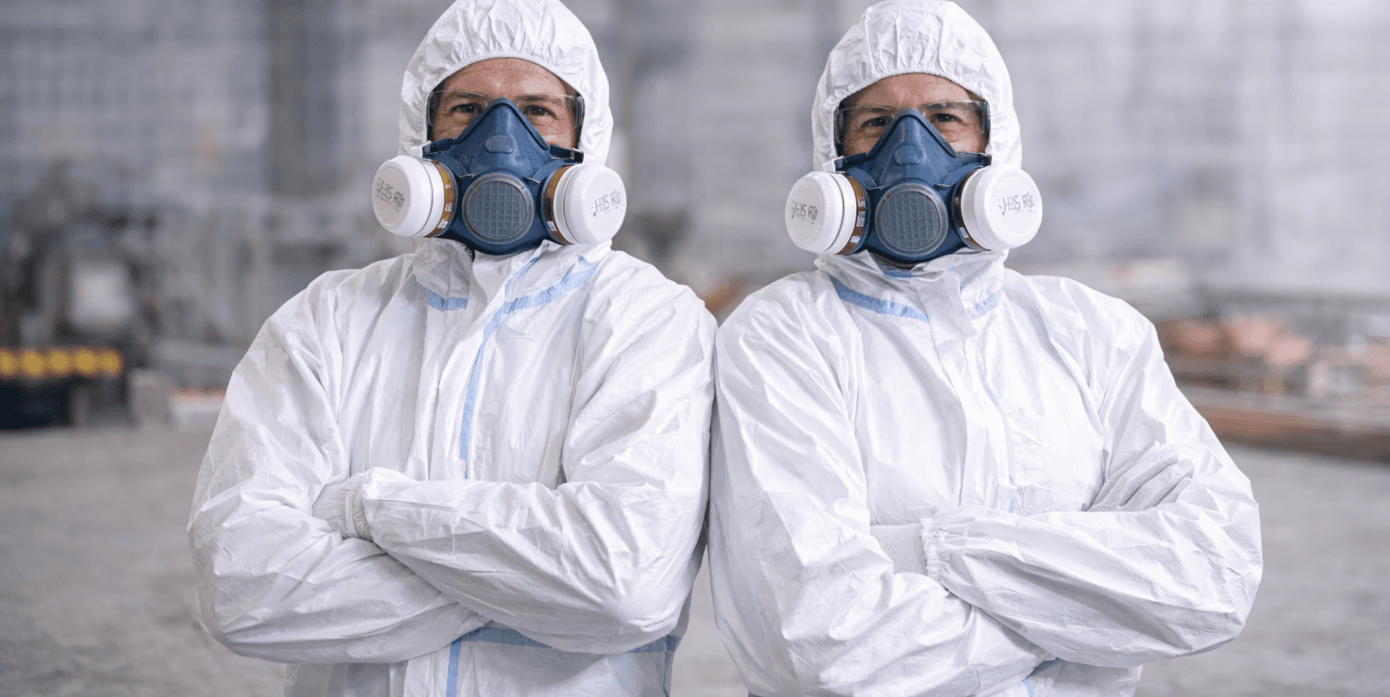 Group of young adults in athletic wear sitting on outdoor steps near a modern overpass, smiling and stretching together in a relaxed, casual moment.
