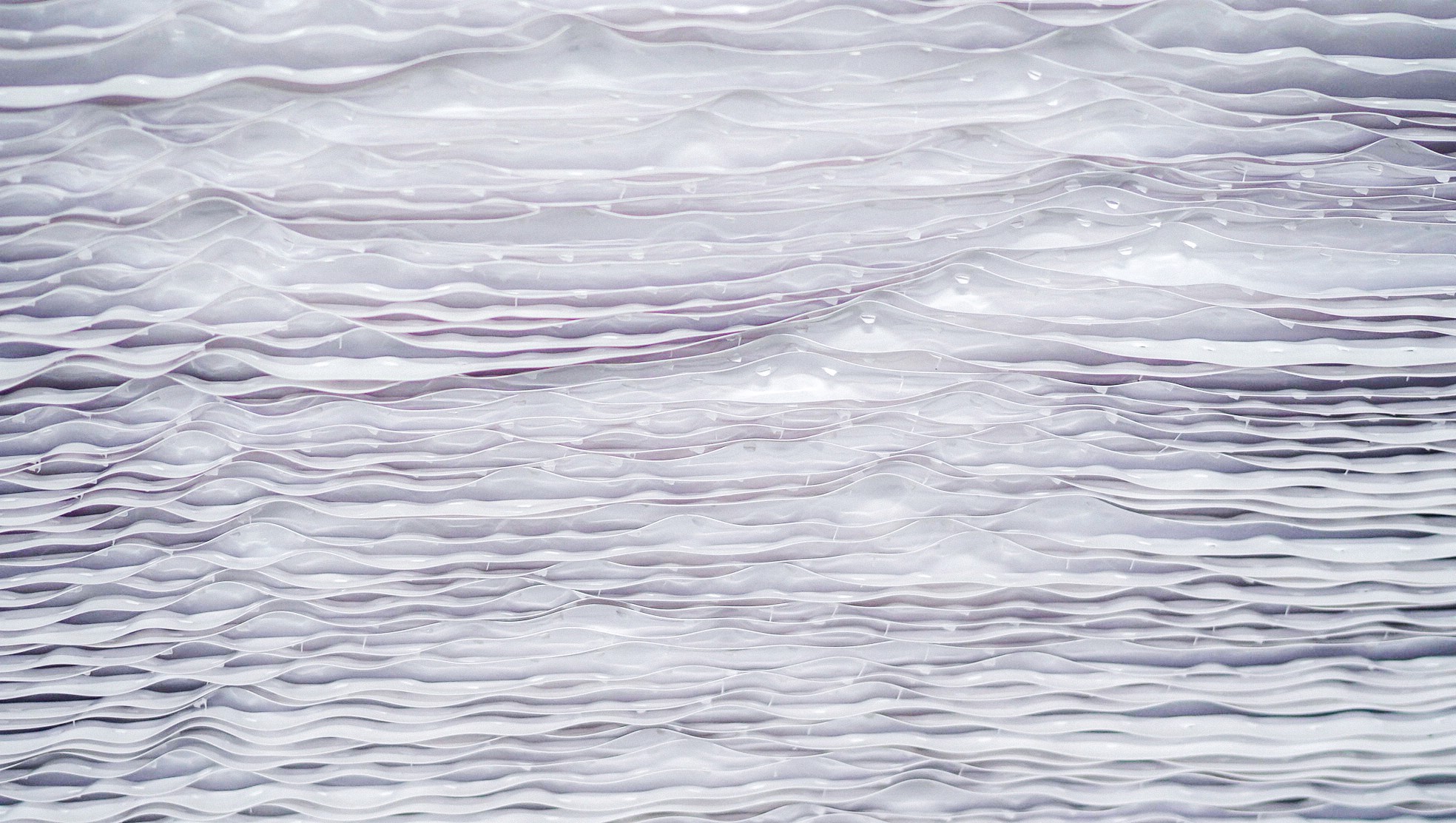 Roll bahan plastik transparan dalam jumlah banyak siap digunakan untuk proses produksi kemasan plastik di pabrik manufaktur. Stok roll bahan baku plastik untuk pembuatan kemasan blister di industri manufaktur, Roll plastik PET dan PVC dalam gudang produksi kemasan plastik industri, Material roll plastik siap proses thermoforming dan vacuum forming kemasan plastik.