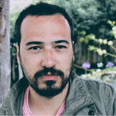 a man with a goatee smiles at the camera