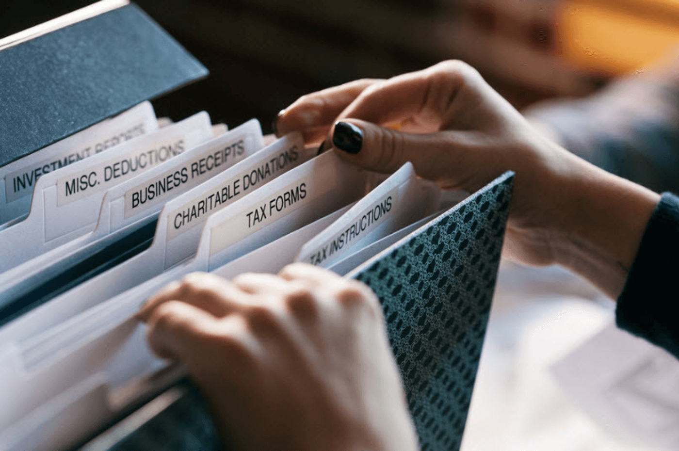 Woman Digging Through Tax File Folder For Forms 