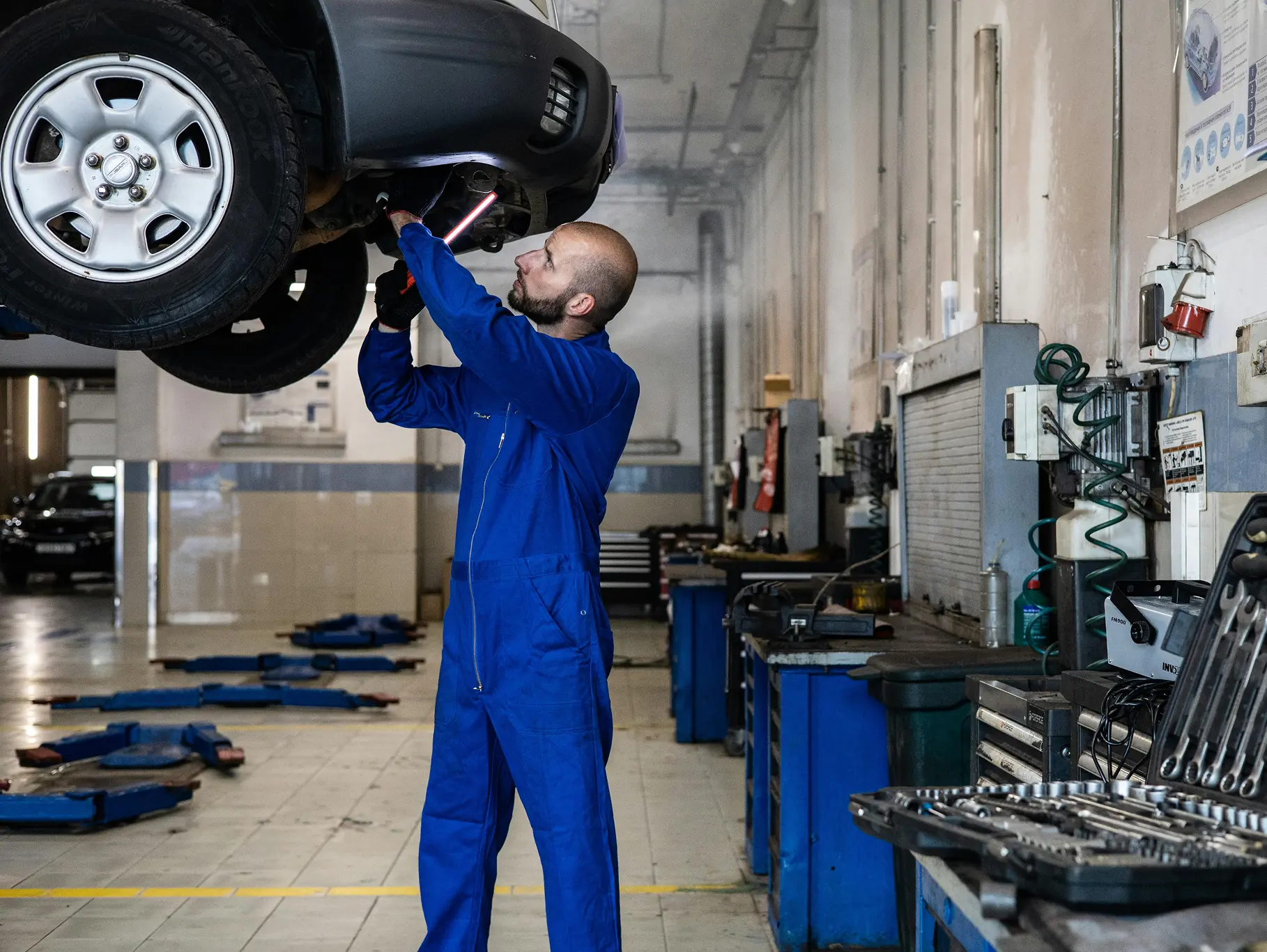 Car repair technician inspecting a vehicle, illustrating how auto repair websites turn visits into service appointments