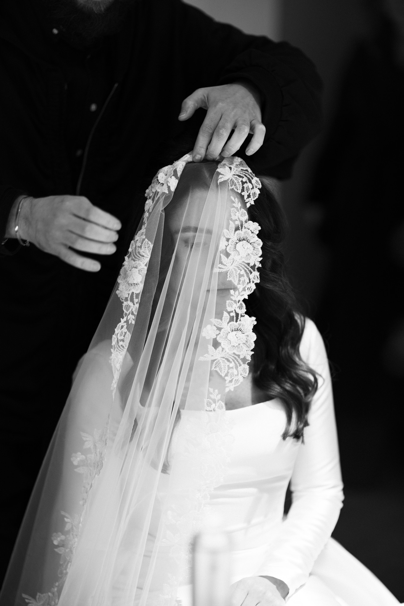 Sposo sistema il velo ricamato della sposa durante i preparativi matrimoniali al Circolo di Lettura di Parma