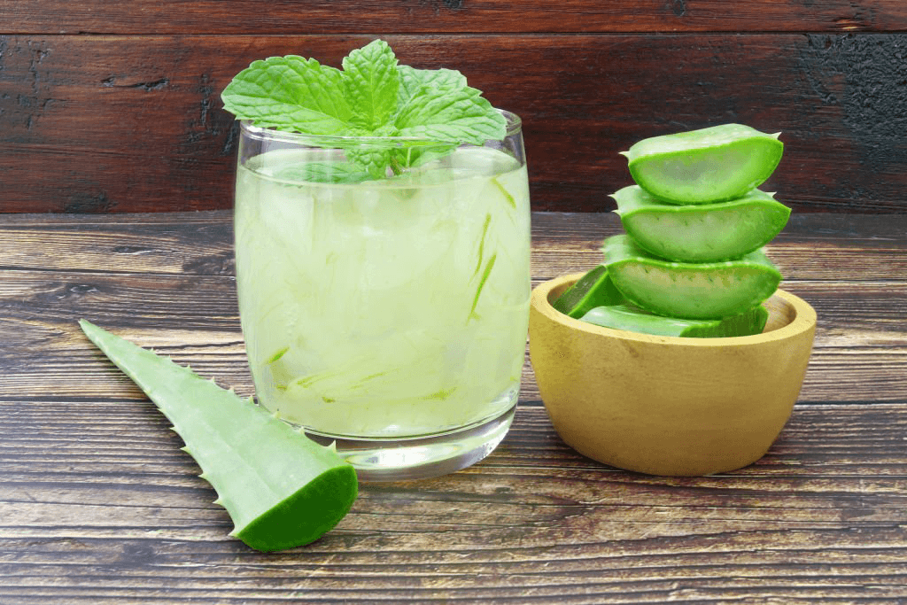 Refreshing aloe vera detox drink in a glass with fresh aloe vera slices and mint leaves.