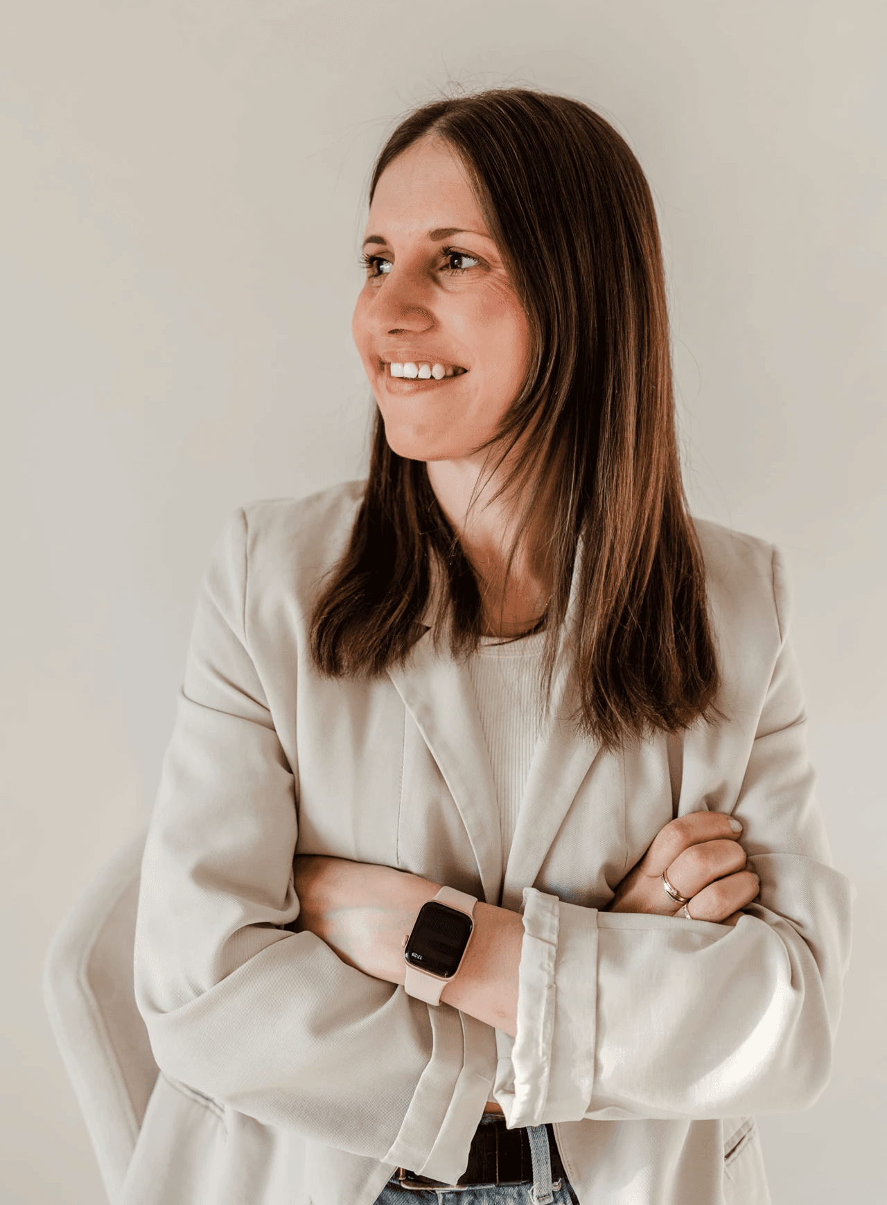 Webdesignerin Verena von OHNORD studio aus Straubing steht, die Arme verschränkt mit einem Lächeln im Gesicht vor einer hellen Wand. Sie strahlt Ruhe und Minimalismus aus. Genau das, was das Website Studio von OHNORD studio aussagen möchte. 