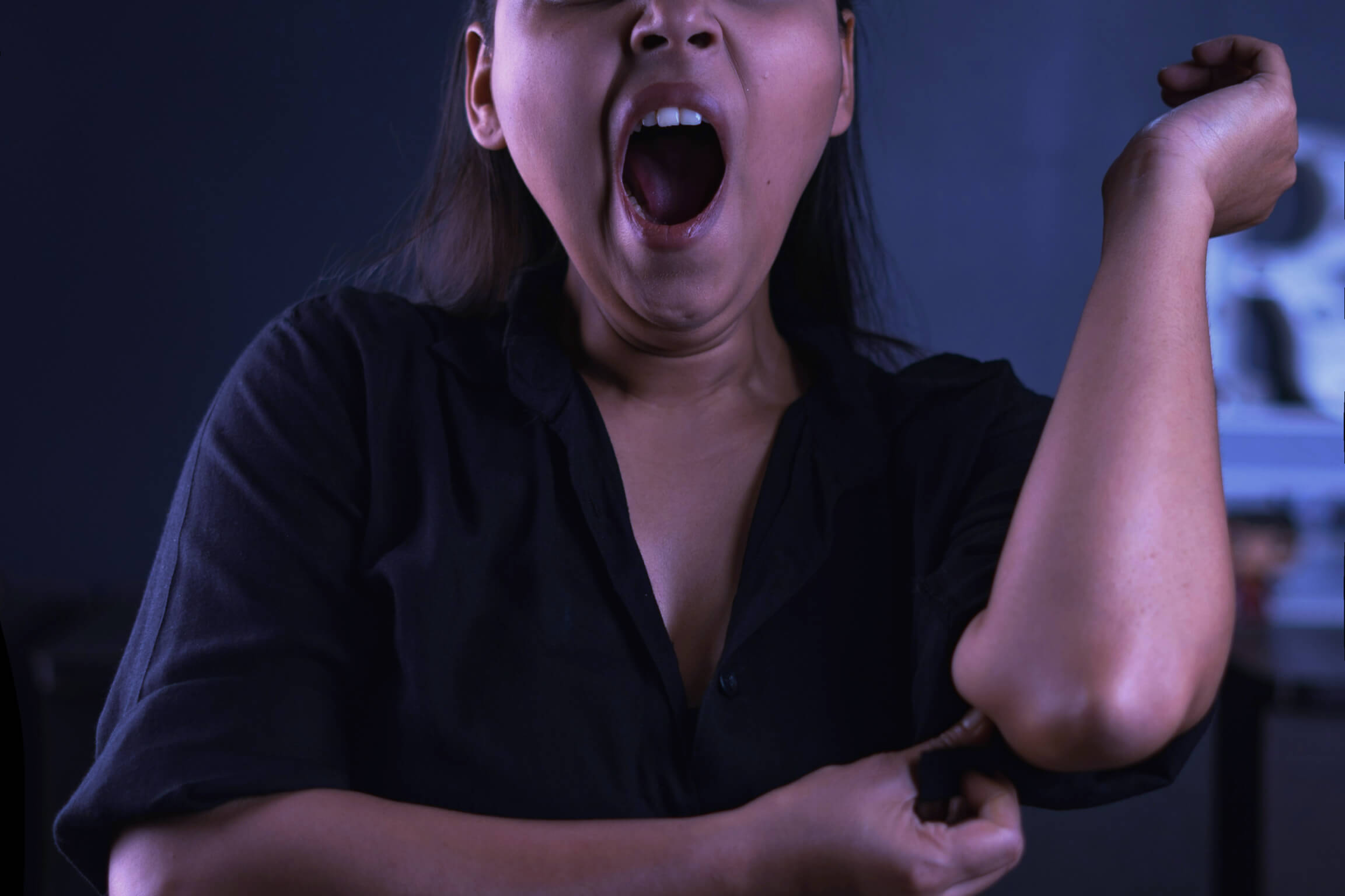 Woman yawning holding elbow