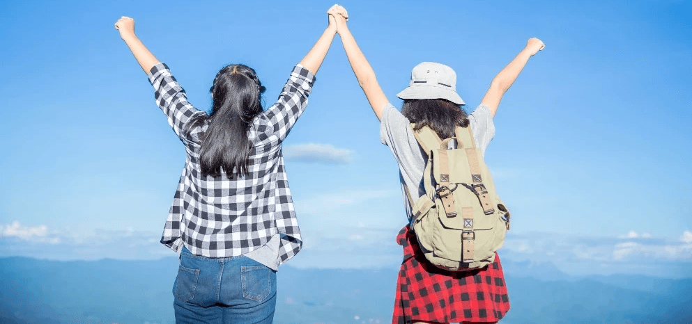企業獎勵旅遊及團隊建立活動策劃，參加者於戶外景點舉手慶祝旅行團體驗。