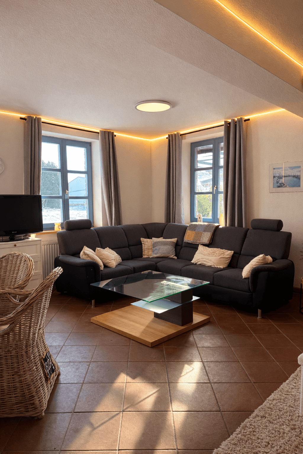 Wohnzimmer im Reetdach-Ferienhaus beim Hotel Rügenschmiede auf Rügen nahe Hiddensee mit gemütlichen Sofa und moderner Ausstattung.