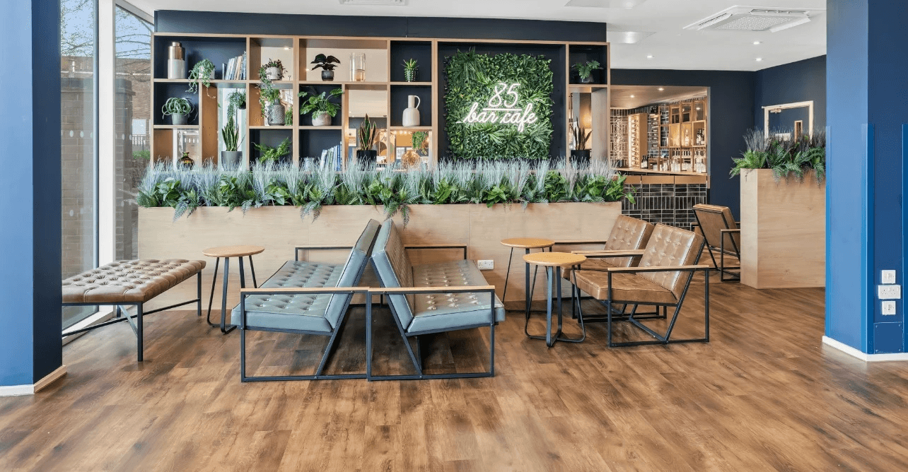 Close-up of a dark green leaf showing its textured surface and central vein against a muted background.