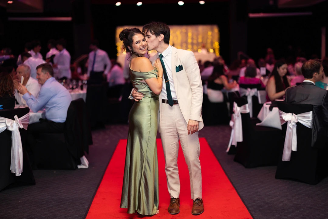 Couple kissing on red carpet at wedding